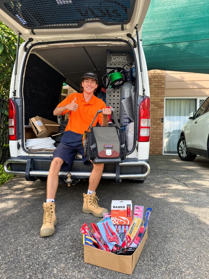 An NDR technician beside a service van at a residential property