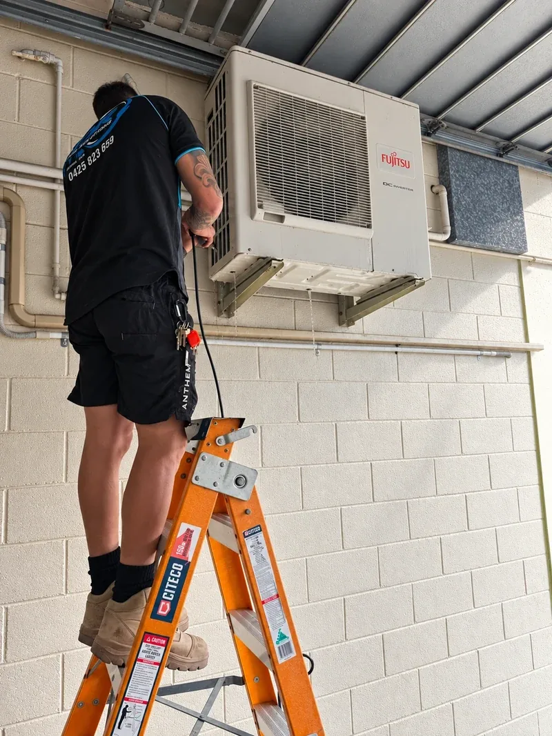 An NDR technician inspecting an outdoor air conditioning unit